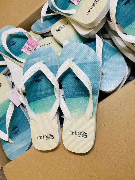 Havaianas comemorativas em caixa — gradiente limpo e texto “arbit 25 anos” na borracha